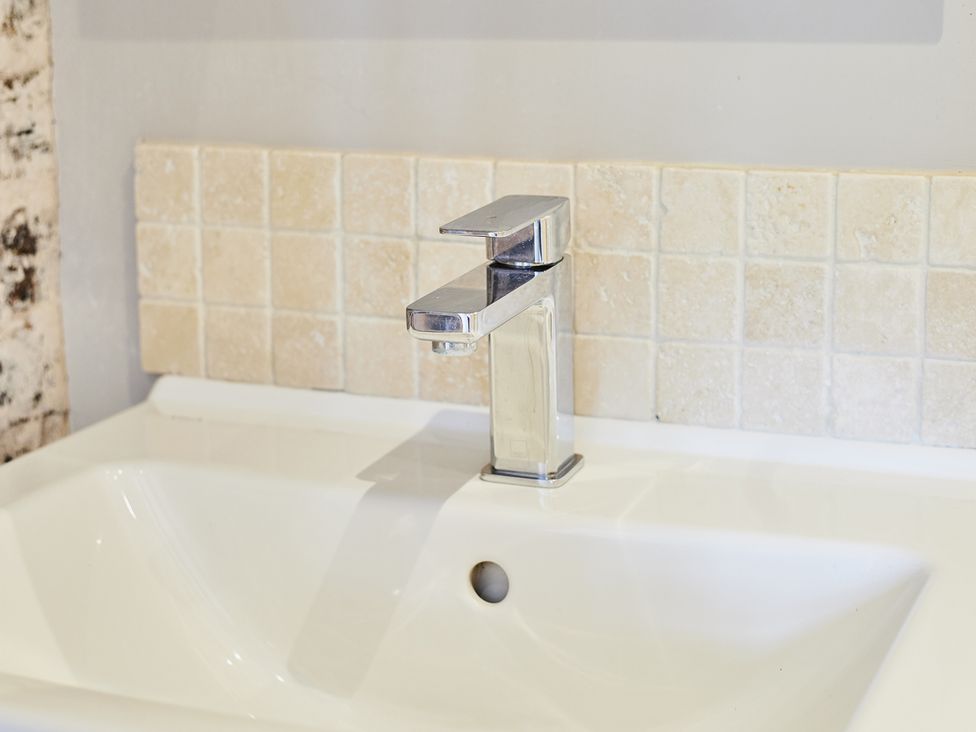 A sink with a faucet and wall tiles in Rook Hall Farm Butterton near Newcastle-Under-Lyme