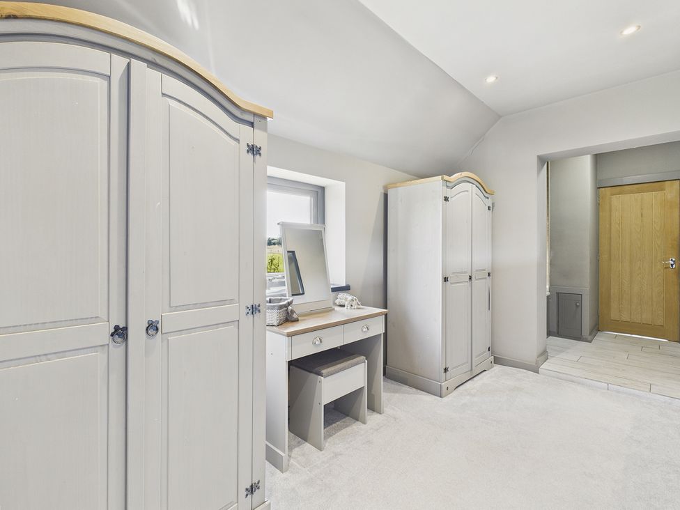 A bedroom with a wardrobe and dressing table at Rook Hall Farm Butterton near Newcastle-Under-Lyme