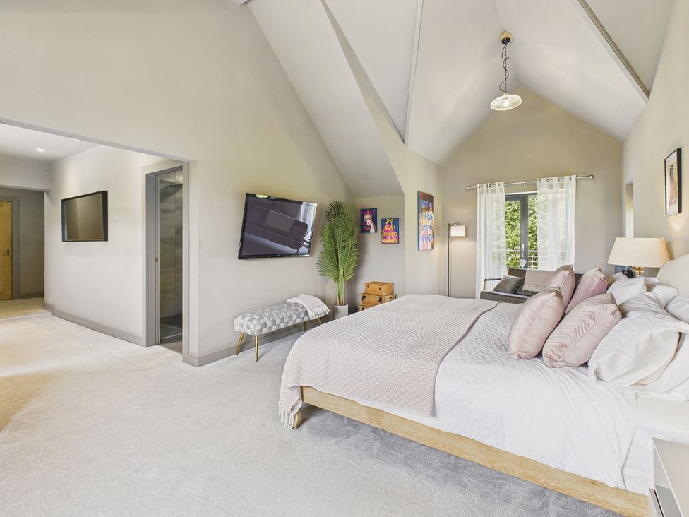 A bedroom with a bed and windows at Rook Hall Farm in Butterton near Newcastle-Under-Lyme