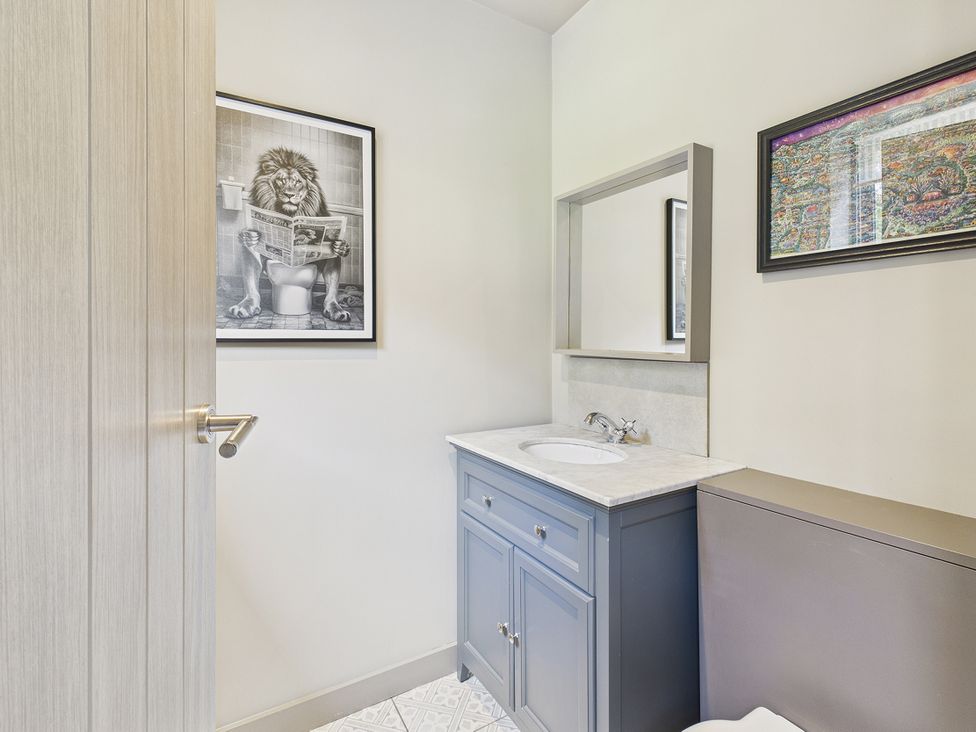 A bathroom with a sink, toilet and wall art at Rook Hall Farm in Butterton near Newcastle-Under-Lyme