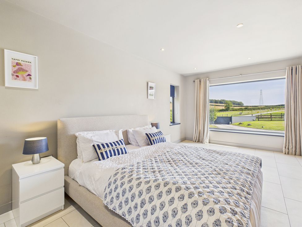 A bedroom with a bed and window view at Rook Hall Farm in Butterton near Newcastle-Under-Lyme
