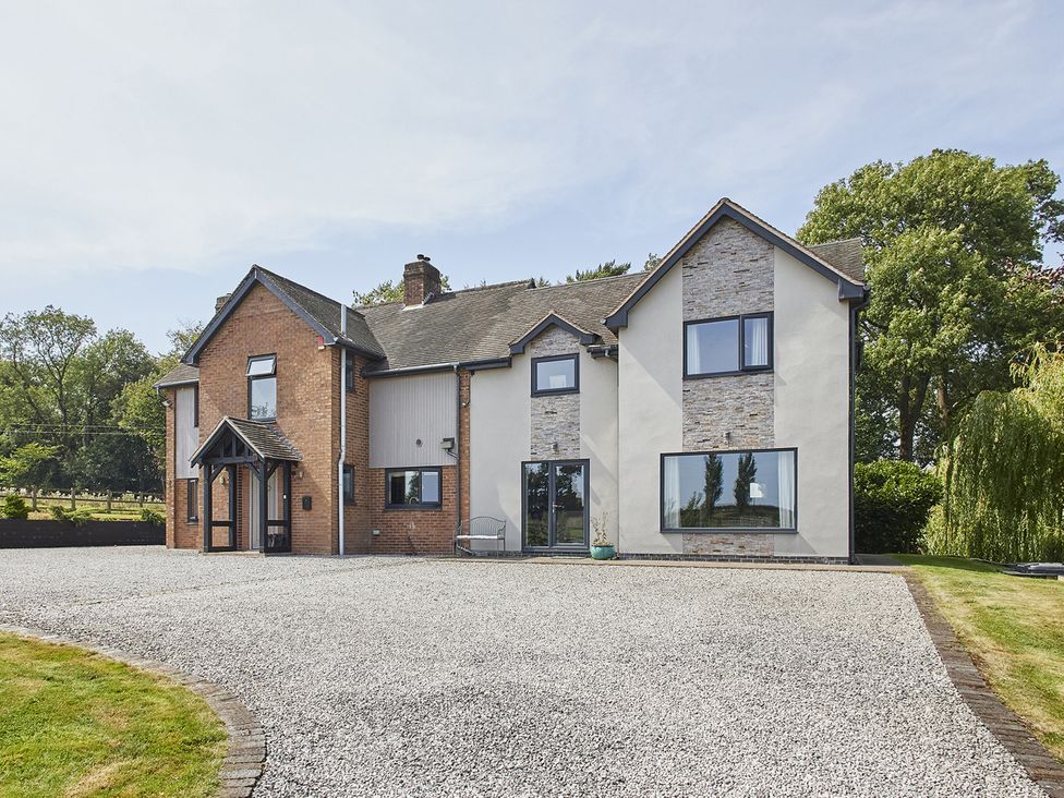 A house with a gravel driveway and garden at Rook Hall Farm Butterton near Newcastle-Under-Lyme