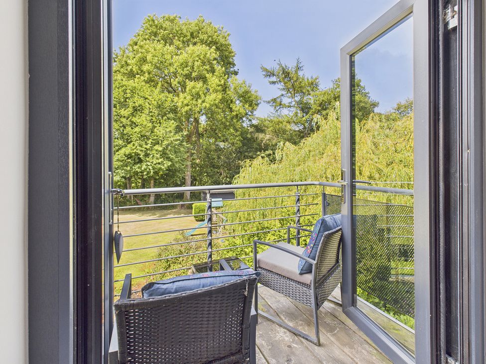 A balcony with chairs overlooking a garden at Rook Hall Farm Butterton near Newcastle-Under-Lyme