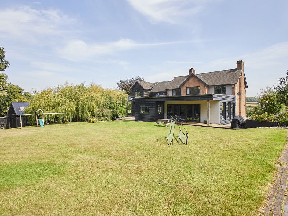A house with a garden and swing set at Rook Hall Farm near Newcastle-Under-Lyme