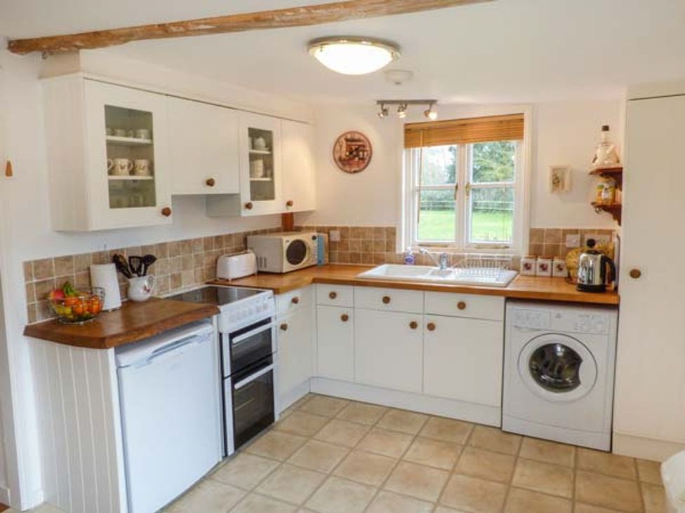 A kitchen with appliances and cabinets at Sheepwash Barn