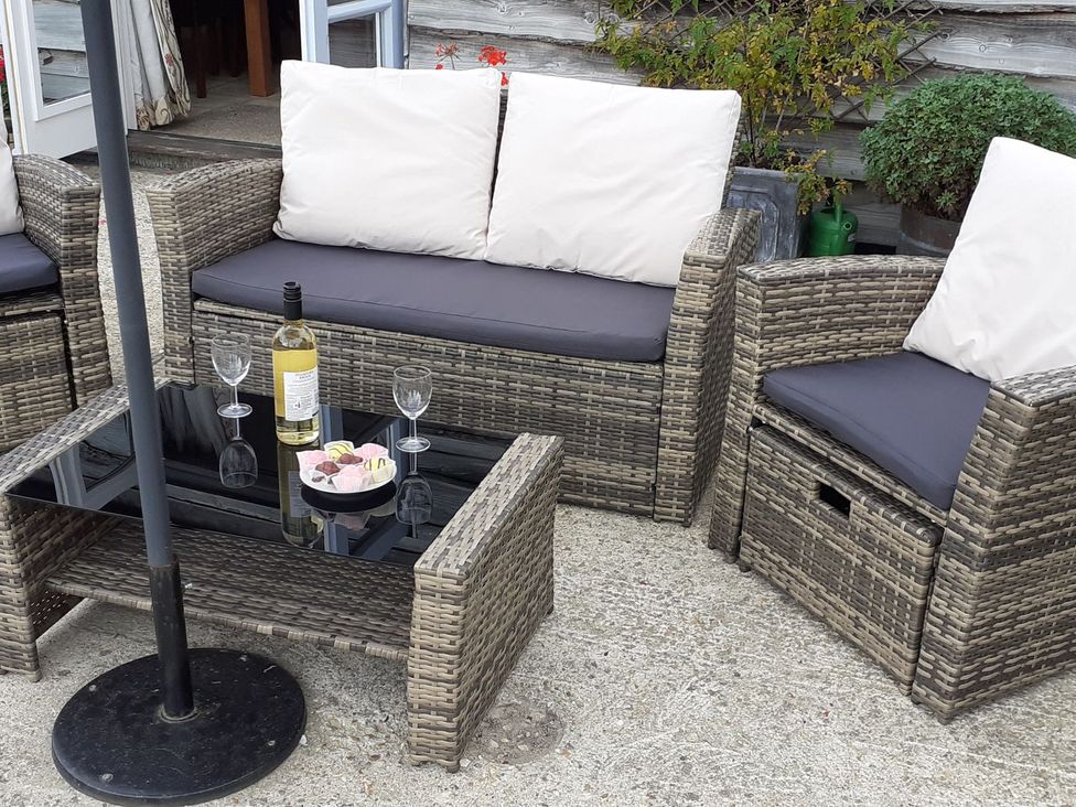 A seating area with a sofa and armchairs at Sheepwash Barn
