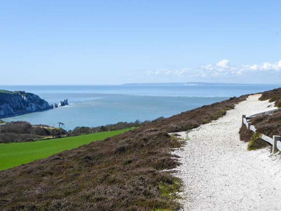 A pathway and cliffs near the ocean at Sheepwash Barn in 