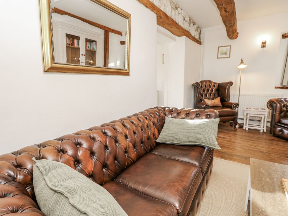 A living room with a leather sofa and armchairs at Sheepwash Barn Freshwater