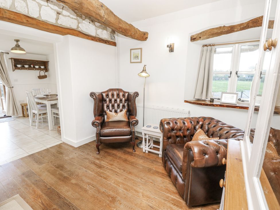 A living room with armchairs and a table at Sheepwash Barn in Freshwater