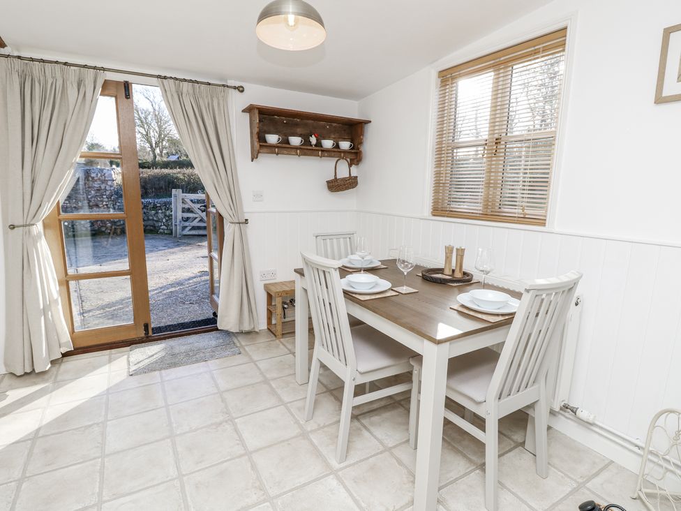 A dining room with a table and chairs at Sheepwash Barn in Freshwater