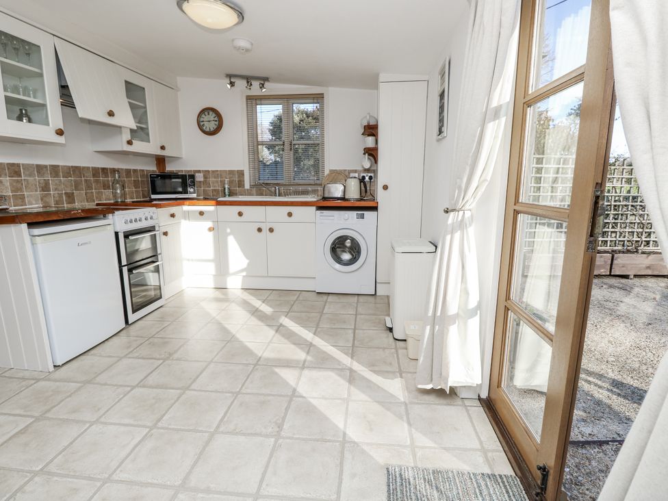 A kitchen with appliances and cabinets at Sheepwash Barn in Freshwater