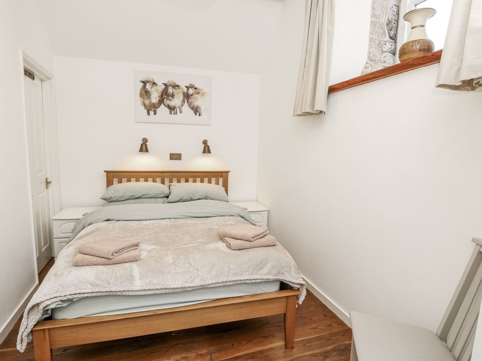 A bedroom with a bed and bedside tables at Sheepwash Barn in Freshwater