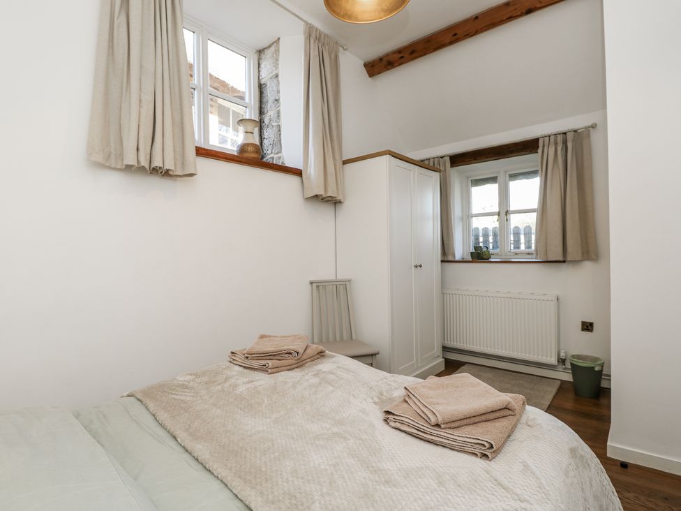 A bedroom with a bed and window at Sheepwash Barn in Freshwater