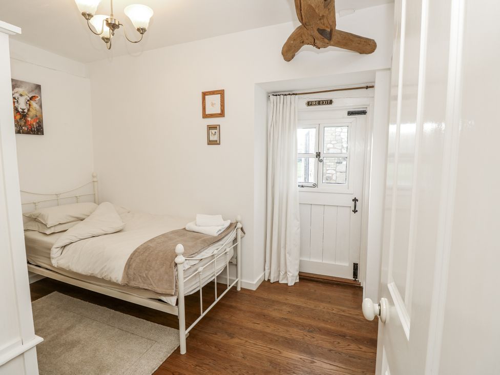 A bedroom with a bed and door at Sheepwash Barn in Freshwater