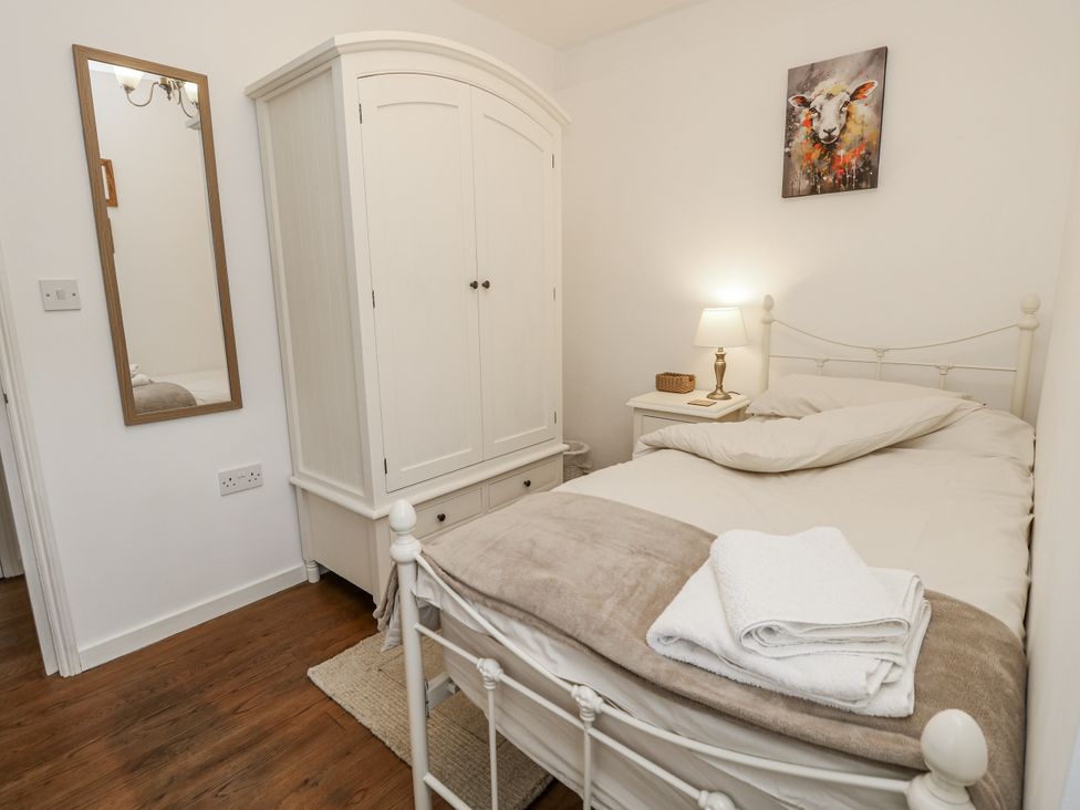 A bedroom with a bed and wardrobe at Sheepwash Barn in Freshwater