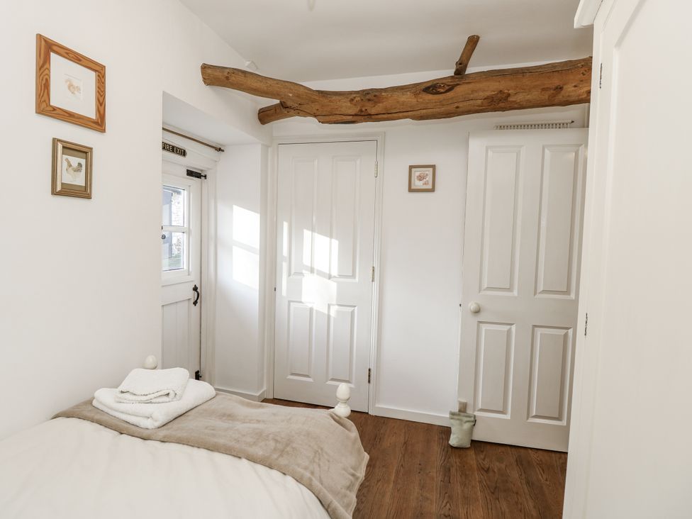 A bedroom with a bed and wooden beam at Sheepwash Barn Freshwater