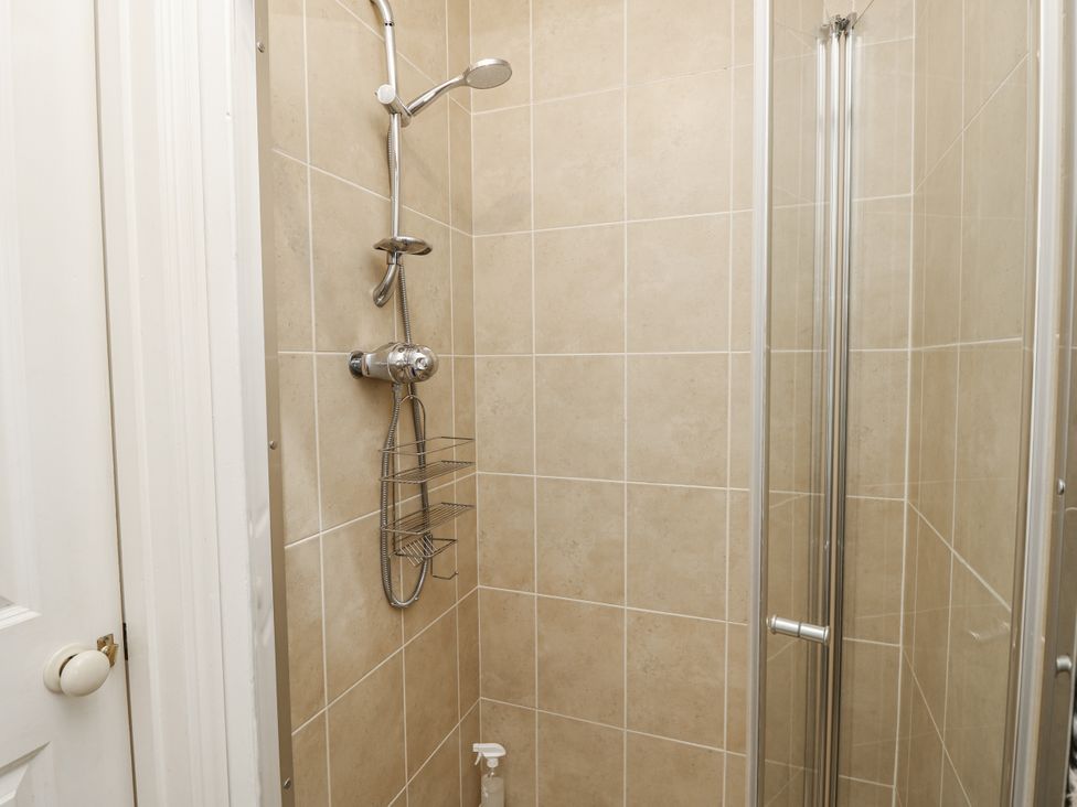 A shower with glass door and wall tiles at Sheepwash Barn Freshwater