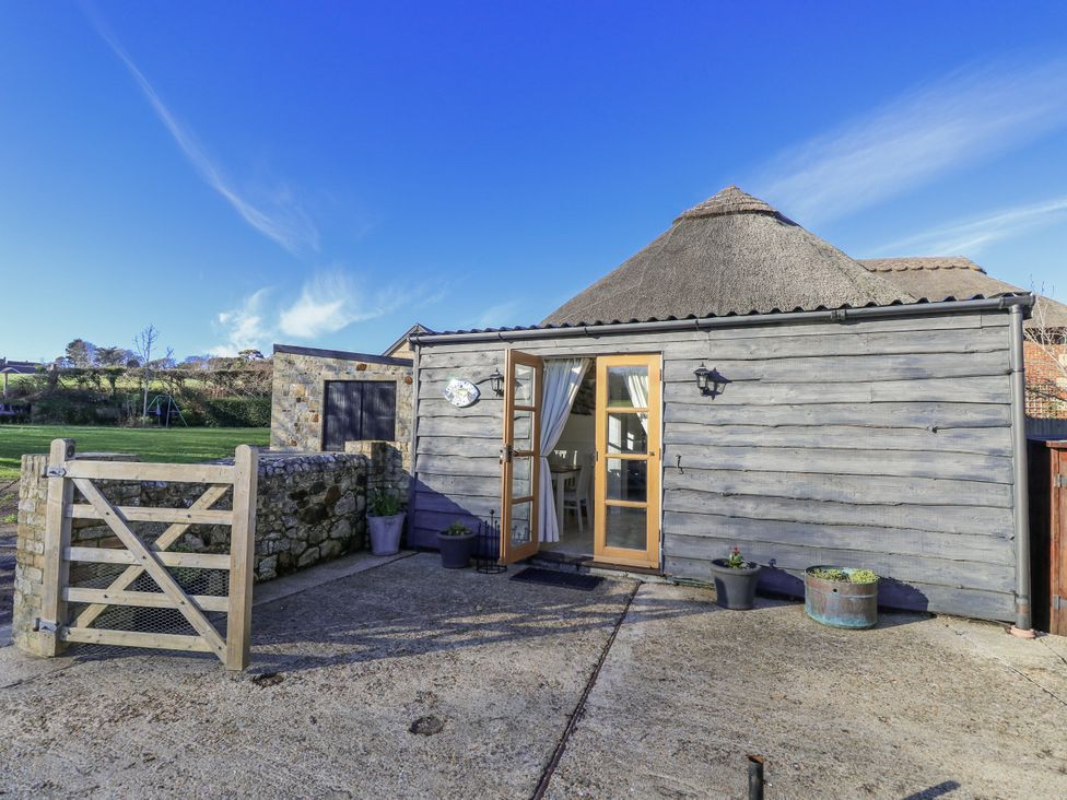 An outdoor area with a wooden gate and a stone wall at Sheepwash Barn in Freshwater