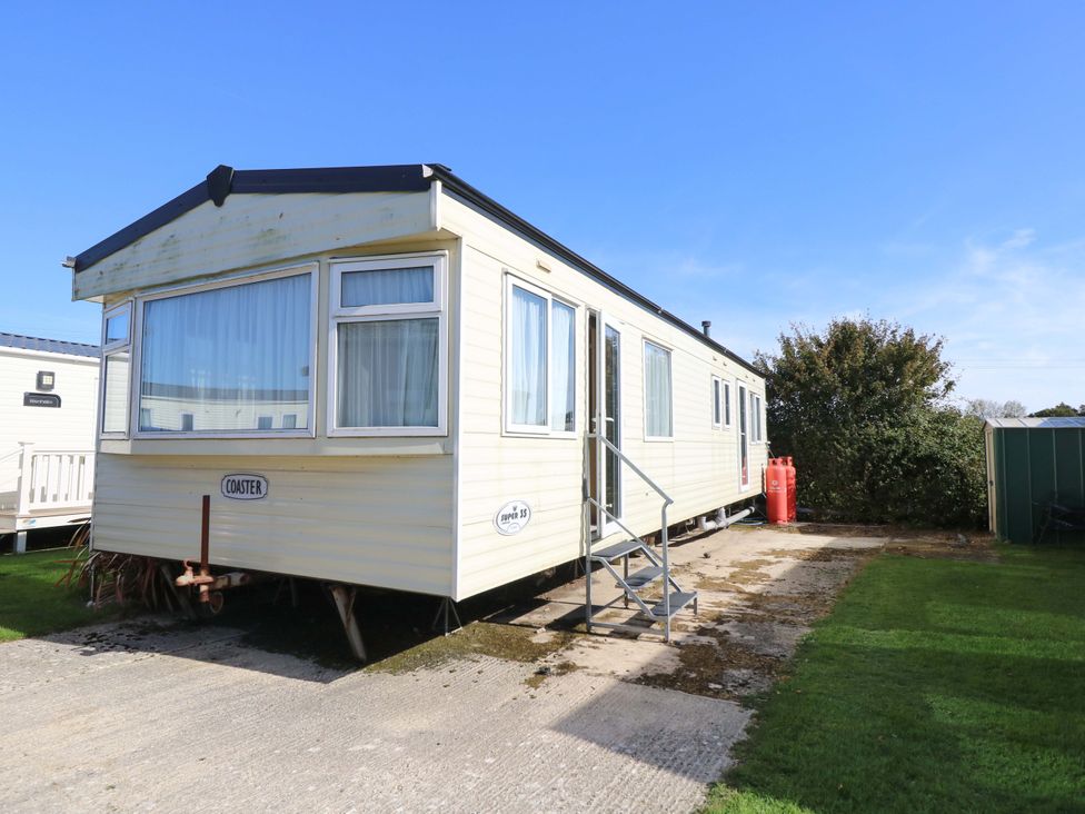 A mobile home with steps and gas bottles at Number 38 in Chichester