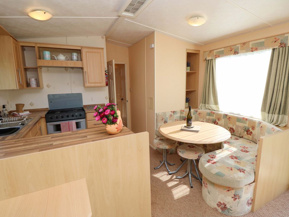 A kitchen with a circular seating area and a wine bottle at Number 38 Chichester