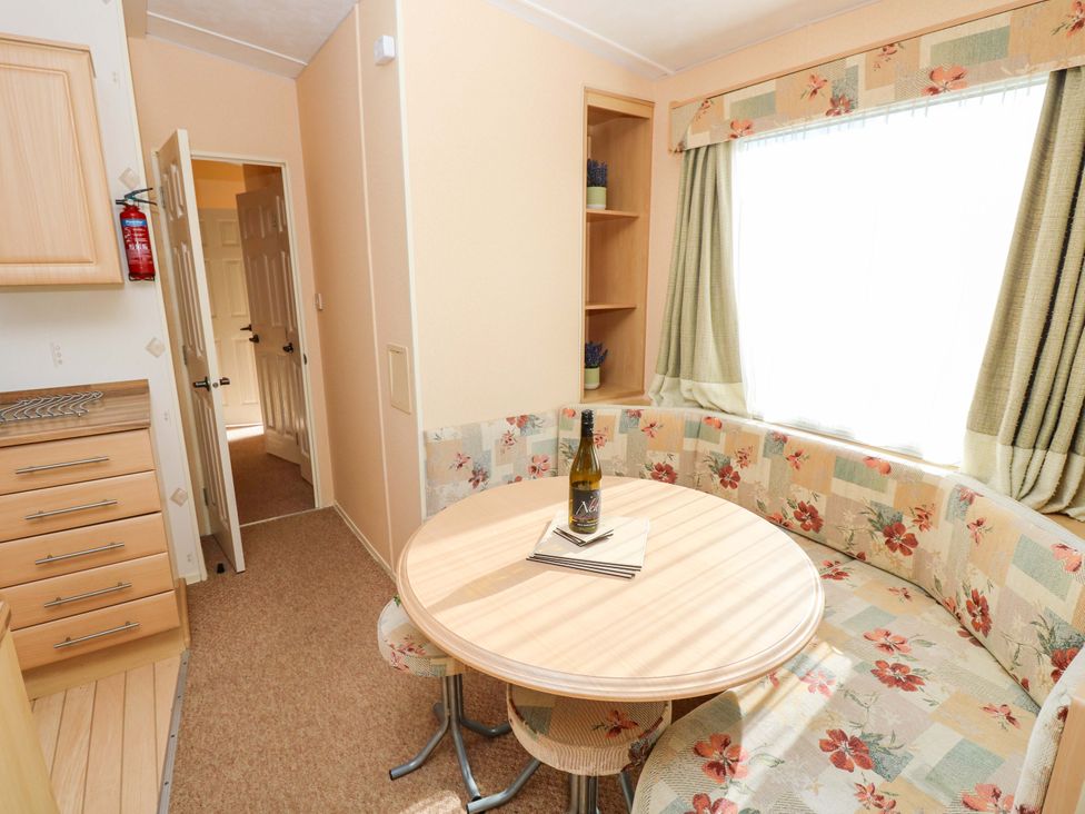 A dining area with a round table and seating at Number 38 Chichester