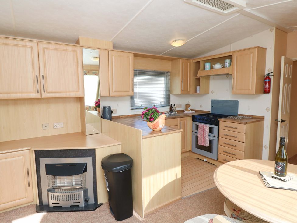 A kitchen with cabinets and a gas stove at Number 38 Chichester