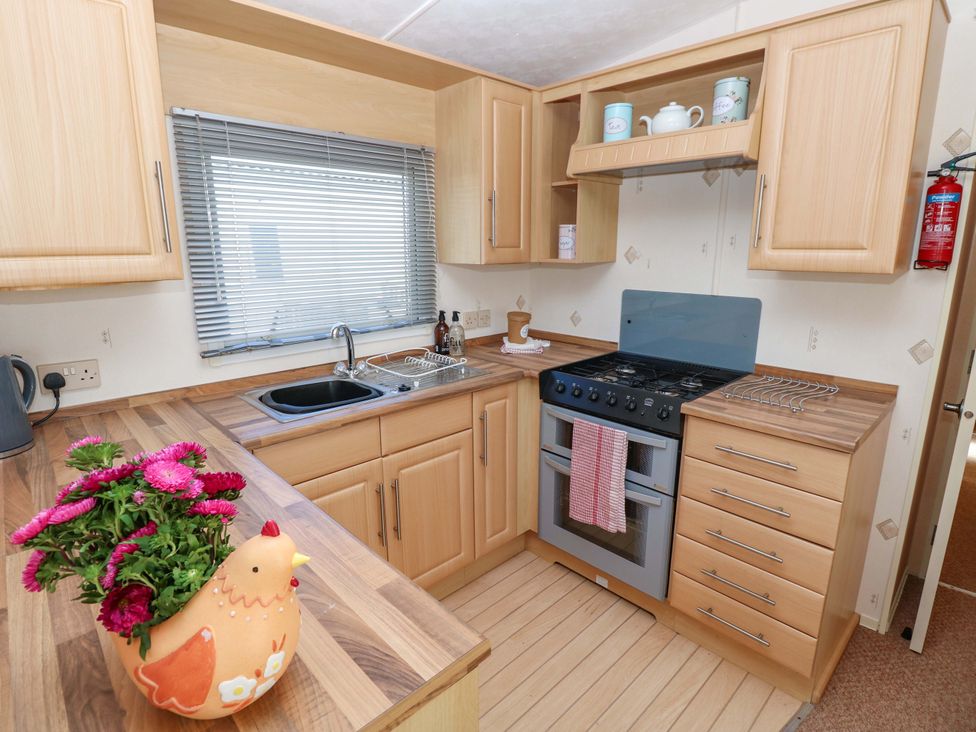 A kitchen with a gas stove and sink at Number 38 Chichester
