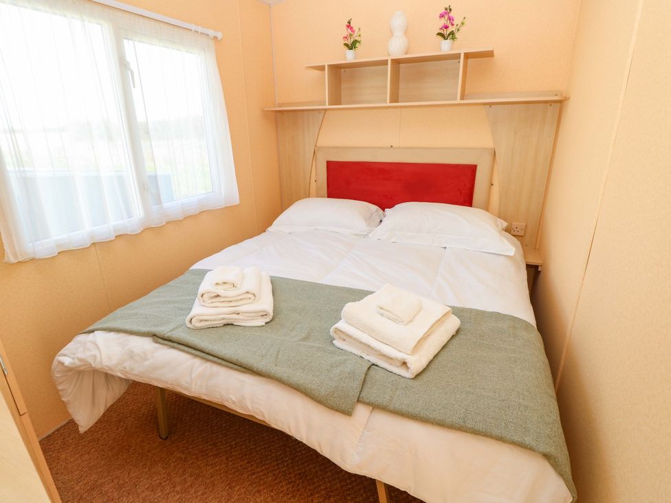 A bedroom with a double bed and shelf at Number 38 Chichester