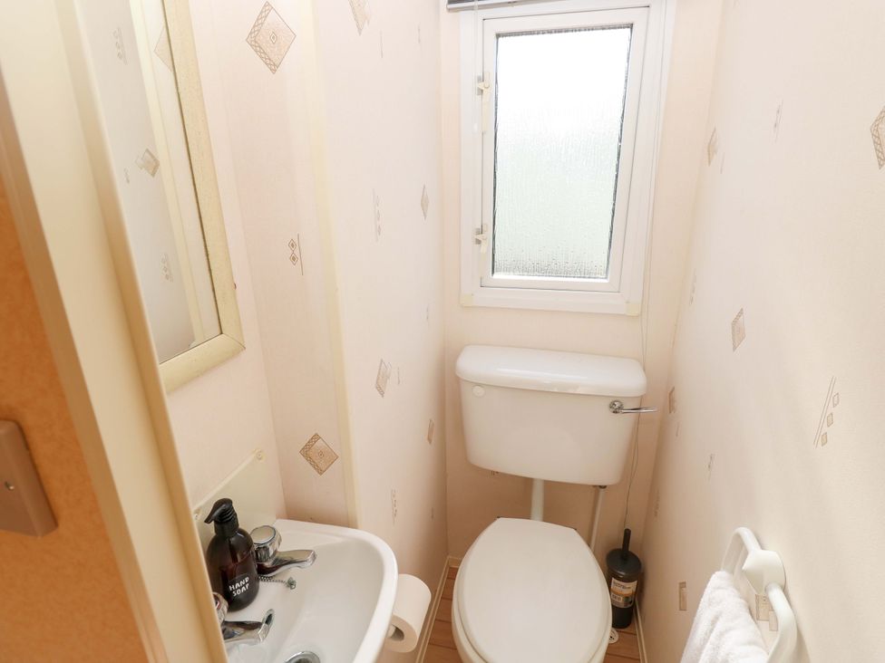 A small bathroom with sink and toilet at Number 38 Chichester