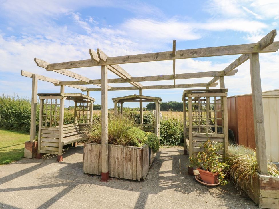 A garden area with wooden pergola and seating at Number 38 Chichester