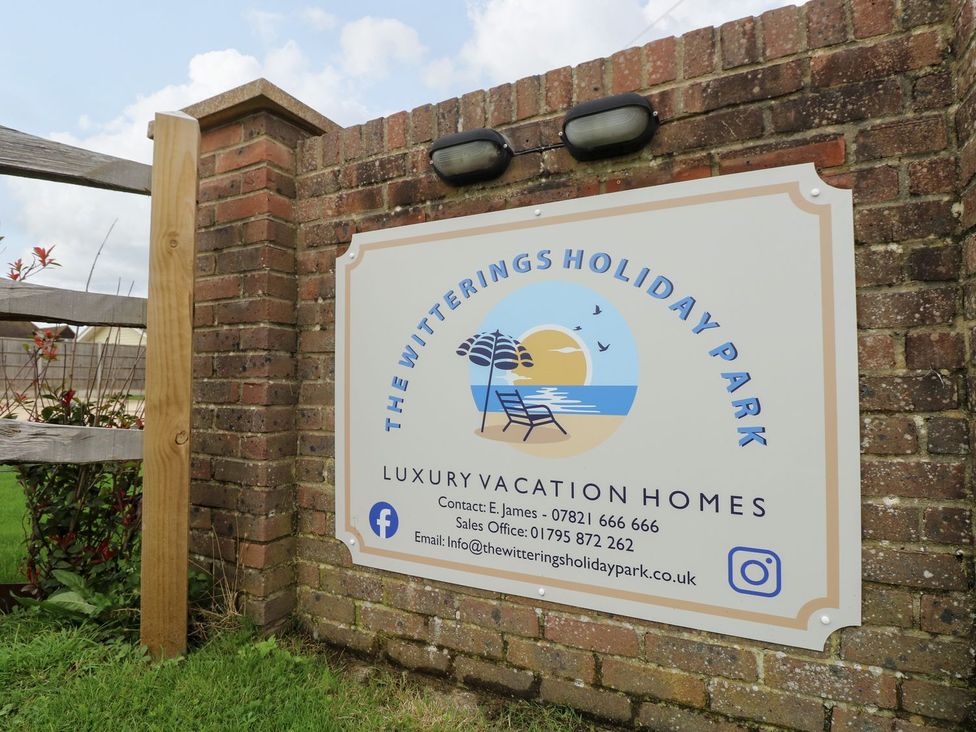 A sign for The Witterings Holiday Park with contact details and logo at Number 38 Chichester