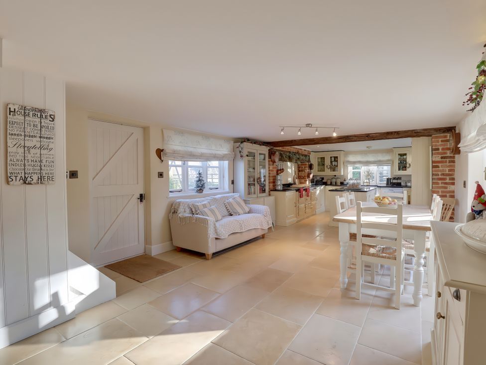 A kitchen with sofa and dining table at Lake Cottage in Swindon
