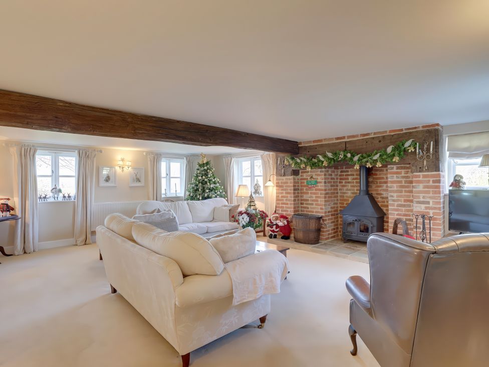 A living room with a fireplace and Christmas tree at Lake Cottage in Swindon