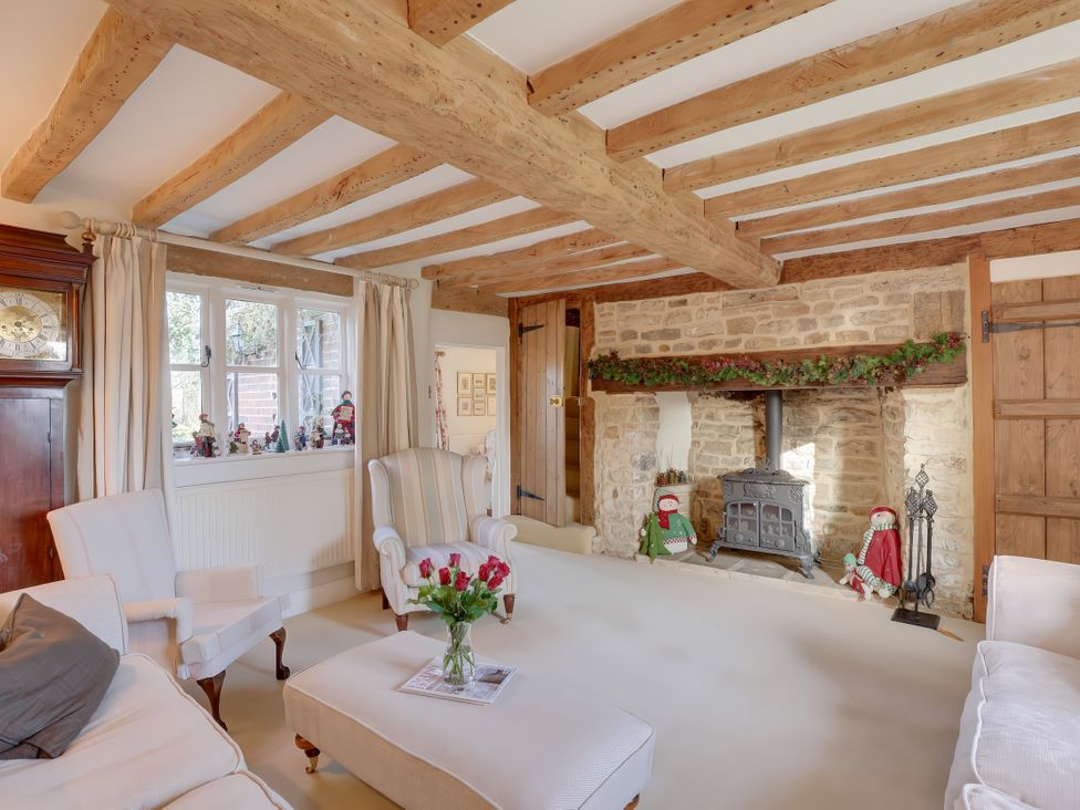 A living room with a fireplace and furniture at Lake Cottage in Swindon