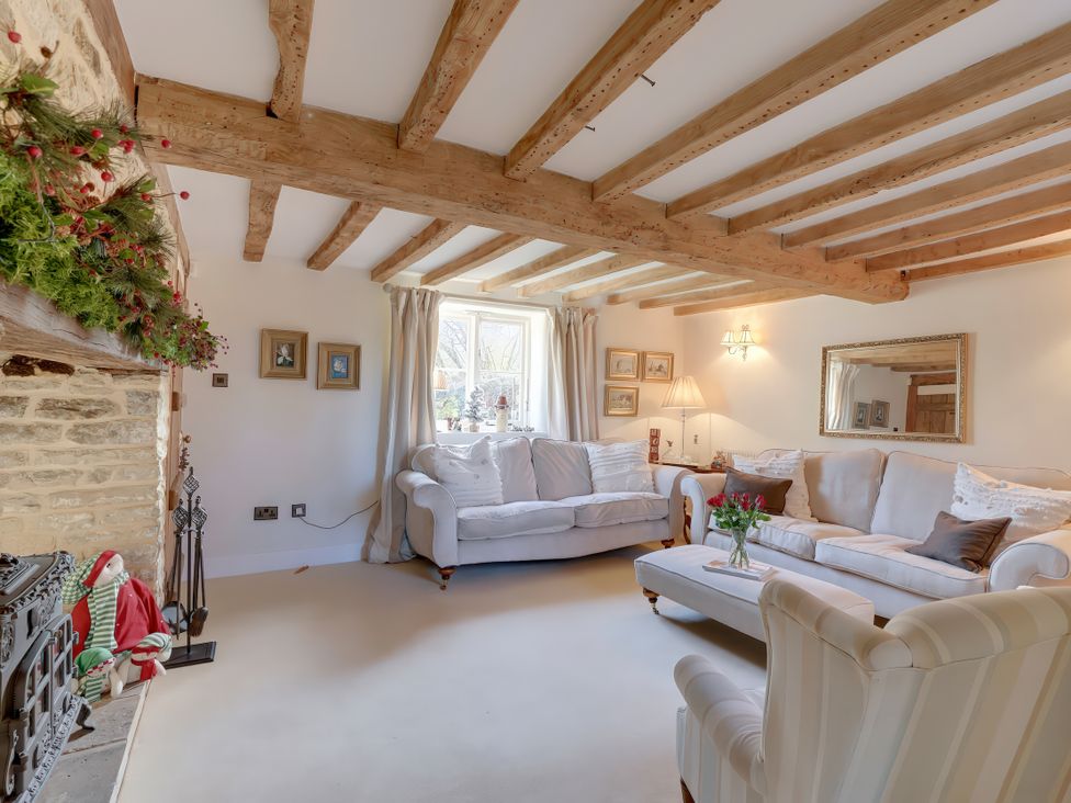 A living room with a sofa and chair at Lake Cottage in Swindon