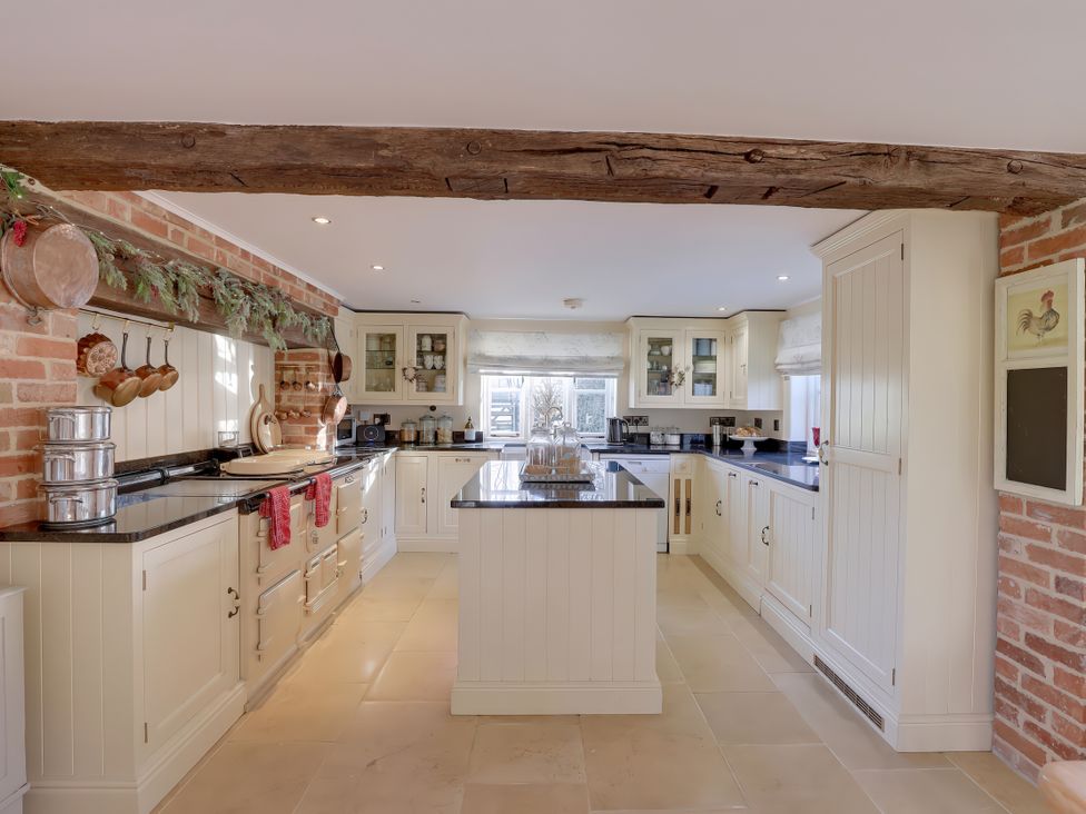 A kitchen with cabinets and appliances at Lake Cottage in Swindon