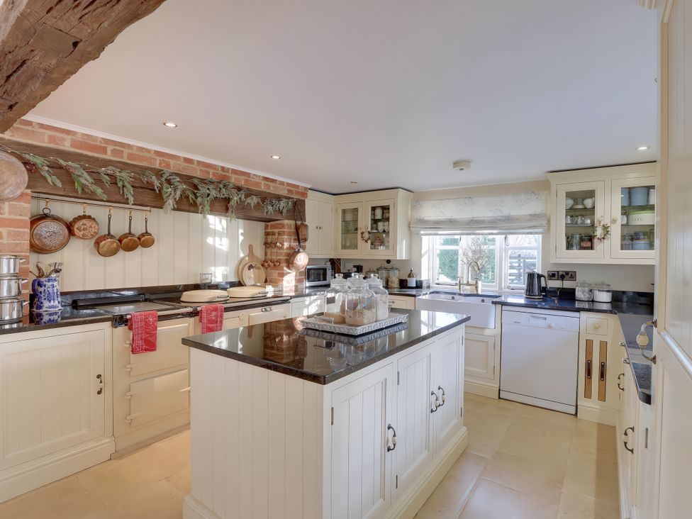 A kitchen with cabinets and appliances at Lake Cottage in Swindon