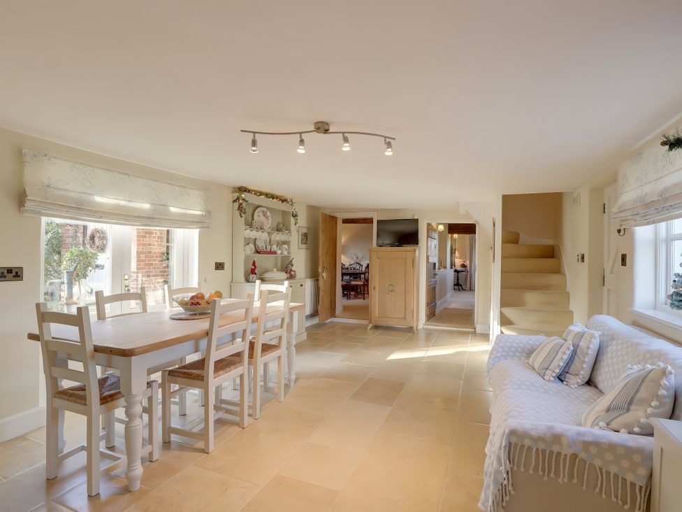 A dining area with a table and chairs at Lake Cottage in Swindon