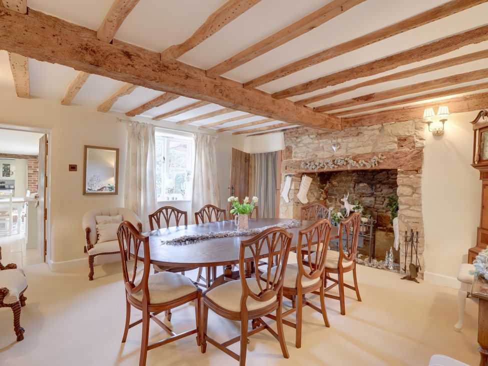 A dining room with a table and chairs at Lake Cottage in Swindon