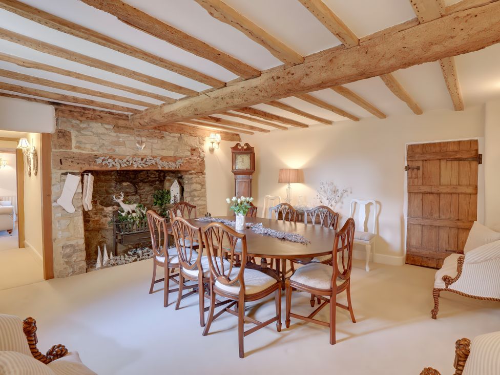A dining room with a wooden table and chairs at Lake Cottage in Swindon
