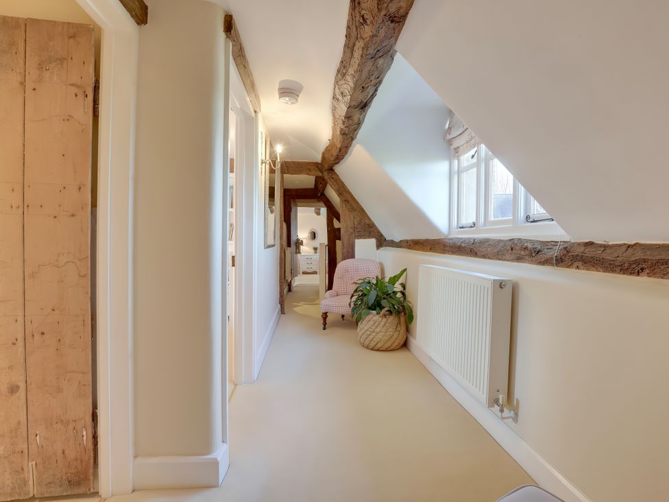 A hallway with a plant and a chair at Lake Cottage in Swindon