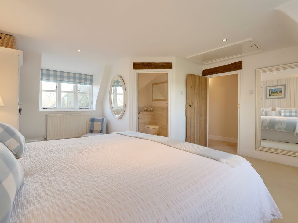A bedroom with a bed and window at Lake Cottage in Swindon