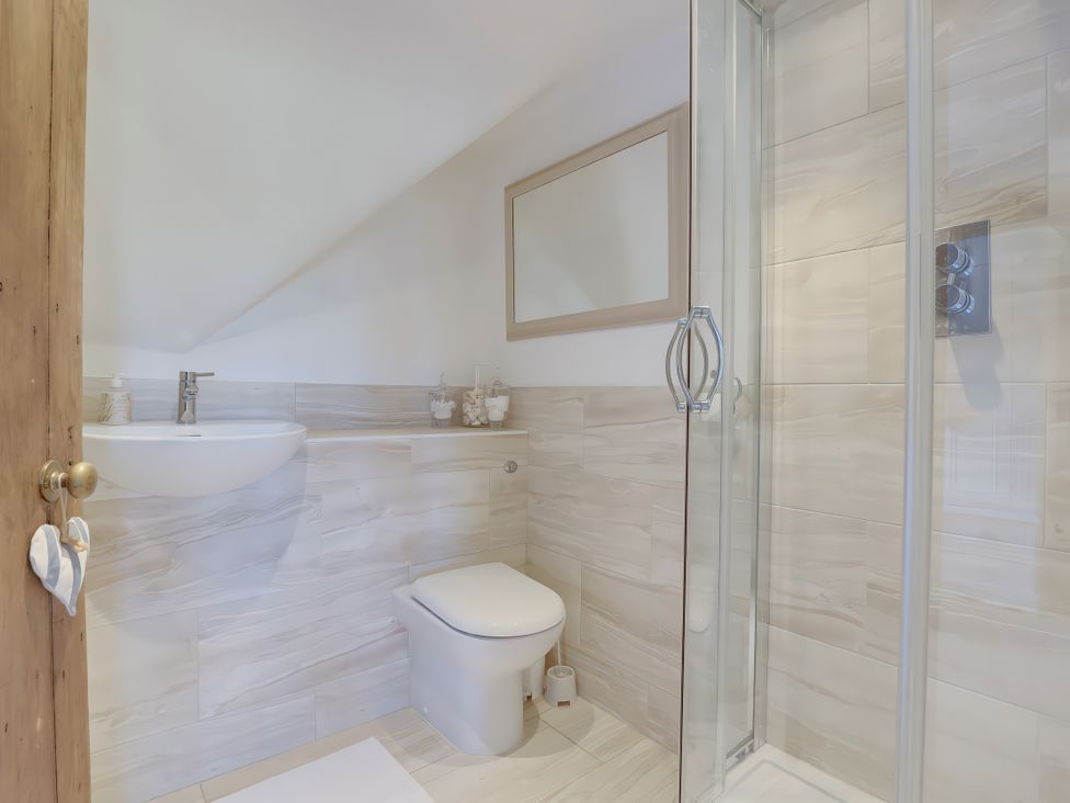 A bathroom with a shower and sink at Lake Cottage in Swindon