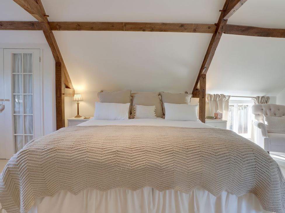 A bedroom with a bed and window at Lake Cottage in Swindon