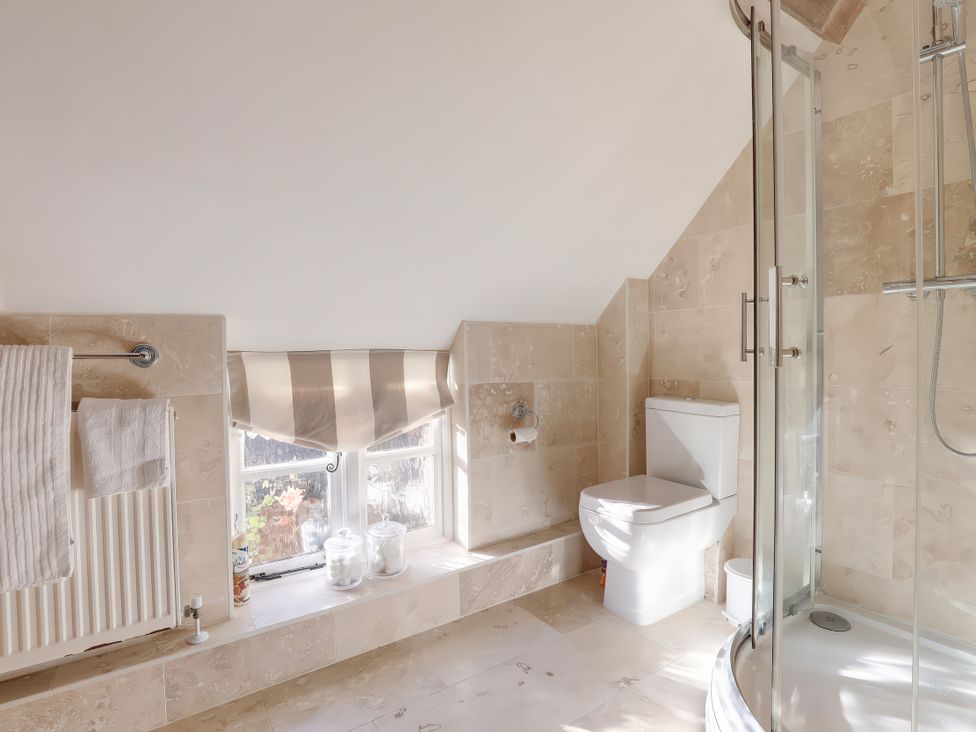 A bathroom with a shower and toilet at Lake Cottage in Swindon
