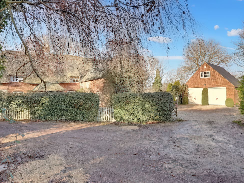 A house and garage with a driveway at Lake Cottage in Swindon