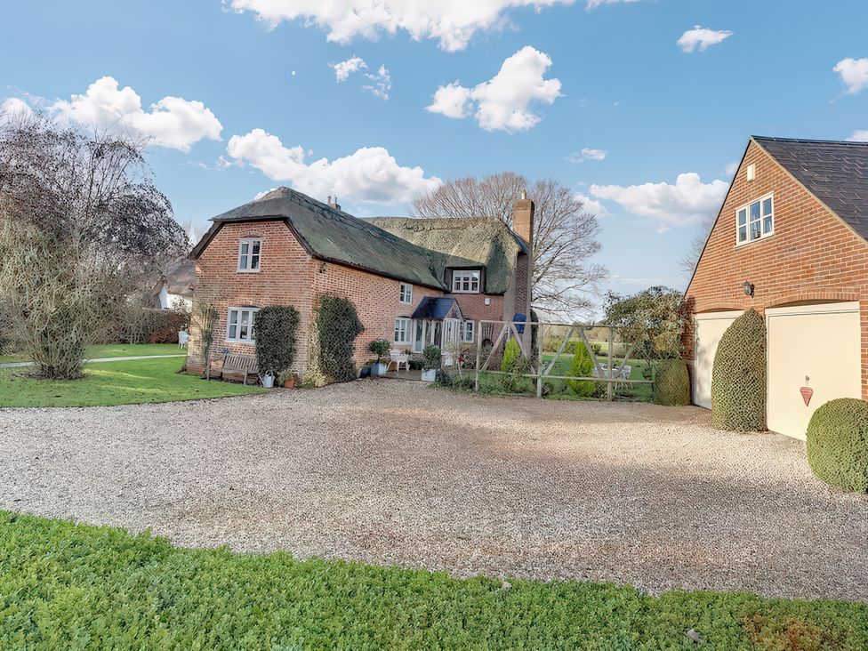 A house with a garage and front yard at Lake Cottage in Swindon