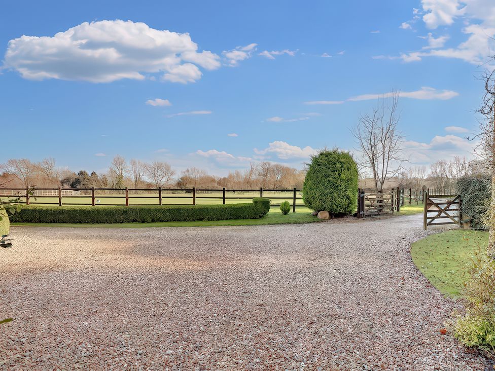 An outdoor area with a gravel driveway and a gate at Lake Cottage in Swindon