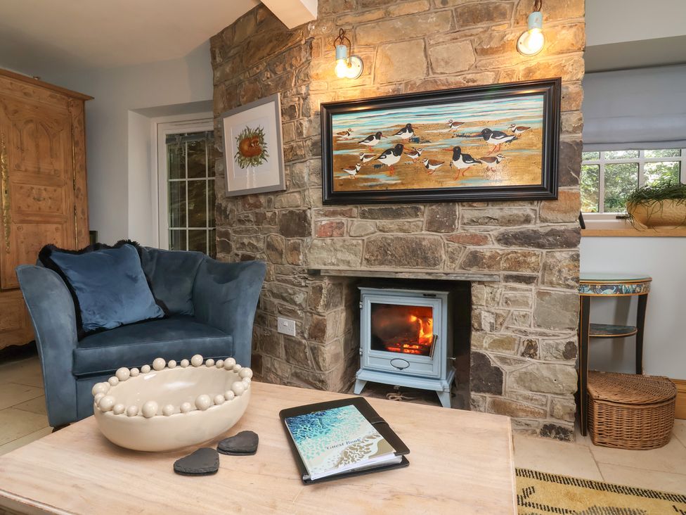 A living room with a sofa and fireplace at Rookery Cottage in Lynton