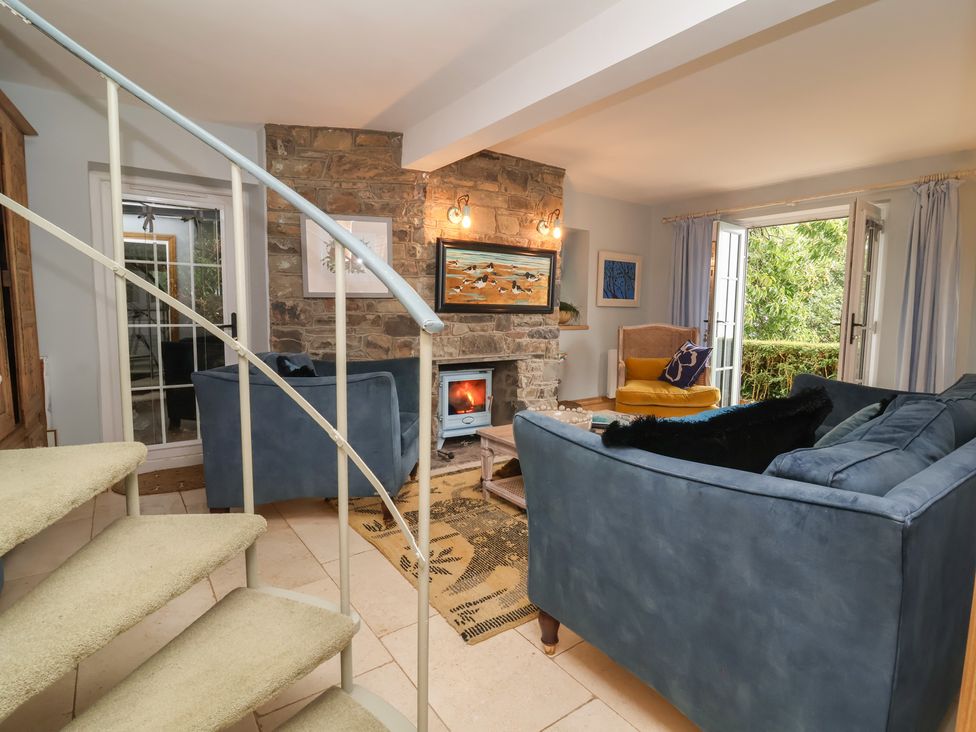 A living room with a fireplace and seating area at Rookery Cottage in Lynton